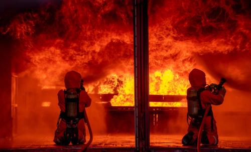 two-firefighters-spray-water-by-sprinkler-to-extin-2022-11-15-12-05-29-utc